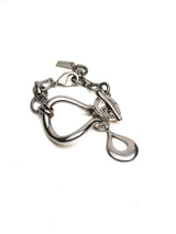 Chunky silver cuff bracelet featuring a heavy, textured design with a T-bar toggle clasp and a drop pendant.