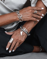Bold silver-plated bracelets featuring unique chain designs and a carabiner closure worn on a model's wrist.
