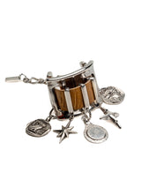 Chunky silver cuff bracelet featuring brown snake-print leather and five dangling silver charm accents.