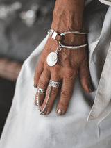 Brown leather wrap bracelet with oversized silver-plated horse bit link, featuring a coin pendant and adjustable clasp.