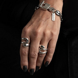 A hand wearing a sterling silver plated ring with strong geometric lines, featuring an adjustable design.