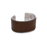 Wide brass bangle featuring beige-toned animal print leather inlay, adjustable open-cuff design for a custom fit.