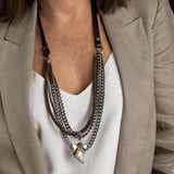 Rock style necklace with gunmetal iron chains, silver-plated tooth pendant, leather accents, and cork cord