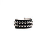 Bold silver bangle with black leather and stud chain, wide statement cuff