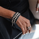 Bold silver bangle with black leather and stud chain, wide statement cuff