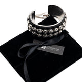 Bold silver bangle with black leather and stud chain, wide statement cuff