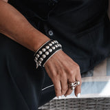 Bold silver bangle with black leather and stud chain, wide statement cuff
