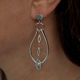 Long silver oval hoop earrings with curb loop design, chain detail, and stainless steel pins, 2.5 inches long