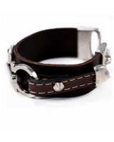 Chunky leather statement bracelet with silver-plated metal details, stitched design, and adjustable chain closure.