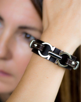 Leather statement bracelet featuring a silver-plated metal design, worn on wrist with a slightly adjustable fit.