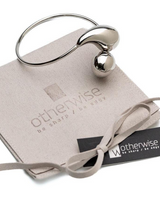 Chunky stainless steel bracelet with large drops, set on an elegant suede pouch, showcasing a high-polished finish.