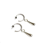 Sterling silver plated hoop earrings with chunky teardrop charms, offering a bold and edgy design.