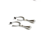 Chunky sterling silver plated hoop earrings with teardrop charms, showcasing a sleek, modern design.