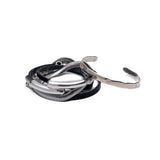 Layered black leather and silver snake chain wraparound bracelet with a hammered silver cuff, showcasing an edgy, minimalist style.