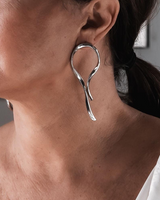 Close-up of a person wearing a silver hoop earring.