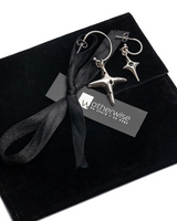Silver star-shaped earrings on a black box with a gray ribbon and 'otherwise' label.