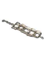 Wide silver-plated zamak arm cuff featuring five unique metal pieces with an adjustable chain for a customized fit.
