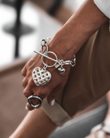 Textured heart charm bracelet in 999 silver, showcasing a woven heart pendant on an antique-plated chain.