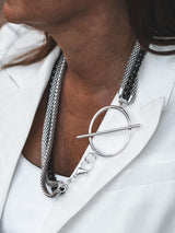 Triple chain necklace featuring silver stainless steel snake chains and a contrasting black aluminum chain, styled with a large T-clasp.