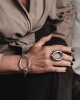 Chunky stainless steel donut ring in gold plating on a model's hand, paired with a matching bracelet, showcasing an edgy style.