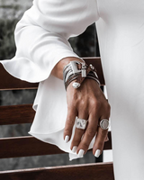 Bold snake chains and woven leather cuff bracelet showcases a layered design with neutral brown leather and silver chains.