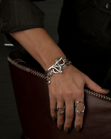 Chic silver bracelet with oval link chain, featuring a Swarovski crystal charm and T-bar closure, worn on a model's wrist.