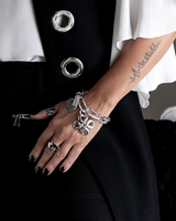 Chunky silver Cuban link chain bracelet featuring an engraved coin and sculpted pendant, worn on a model's wrist.