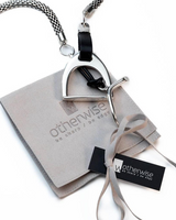 Equestrian-inspired bold stirrup jewelry set featuring a black leather cord and silver-coated stirrup motif on a steel chain.