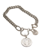 A silver-tone metal chain bracelet with a lobster clasp, a large O-ring, a round coin-style pendant, and a small horse-head charm, shown on a plain white background.