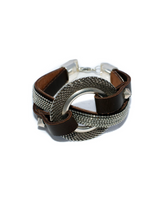 Bold textured disc bracelet featuring dark leather and strass, with a chunky silver centerpiece for a rock style look.