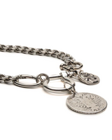 A silver-toned metal chain accessory with a lobster clasp, a large oval ring, a small round engraved charm, and a larger coin-style disc pendant on a plain white background.