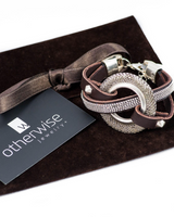 Bold textured disc bracelet featuring leather and strass, adjustable with a strong design and silver accents.