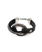 Bold textured disc bracelet featuring black leather and strass, adjustable with a silver clasp for a rock style look.
