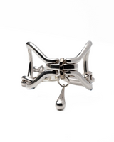 Chunky silver metal cuff bracelet with sculptural link design and a teardrop charm for a bold statement look.