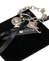 Silver bracelet with charms on a black velvet box with 'Wotherwis' branding.