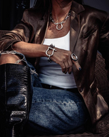 Silver shackle jewelry set featuring a chunky necklace and bracelet with a textured U bolt design, worn with a white top.
