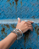 Bold chunky snake chains bracelet with intertwined stainless steel, worn on a model's wrist with a silver ring.