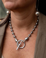 Sterling silver plated ball chain set featuring chunky beads and an organic ring clasp, worn as a necklace with matching earrings.