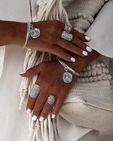 Four boho rings shown on hands with long, manicured nails. Rings feature ethnic designs and are adjustable in size.
