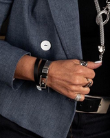 Person wearing a dark blue blazer with a close-up of hands holding a key.
