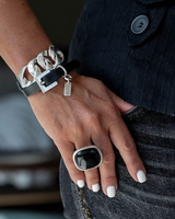 Chunky black leather double wrap bracelet with silver chain links and buckle clasp, worn on a model's wrist.