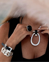 Leather and chunky link bracelet wraps around the wrist, featuring a silver buckle clasp and unique layered design.