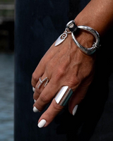 Silver-plated cuff bracelet with genuine leather, featuring a unique artisan design. Worn comfortably on a wrist.