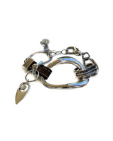 Edgy metal cuff bracelet featuring irregular silver-plated design and a soft brown leather strap, adjustable for a custom fit.