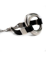 Black leather bracelet featuring a chunky silver metal cuff, adjustable with a chain, for a bold rock style look.