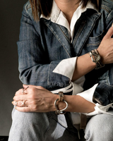 Person wearing a denim jacket and white shirt with a gray background