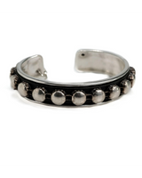 Silver bracelet with circular embellishments on a white background