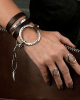 Edgy wrap leather and metal statement bracelet featuring brown leather strands and sculpted silver-plated accents.