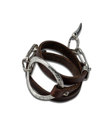 Unique wrap leather & metal statement bracelet featuring soft brown leather strands and sculpted silver-plated metal accents.