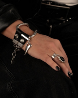 Handcuffed hand with a keychain, wearing a black leather jacket.